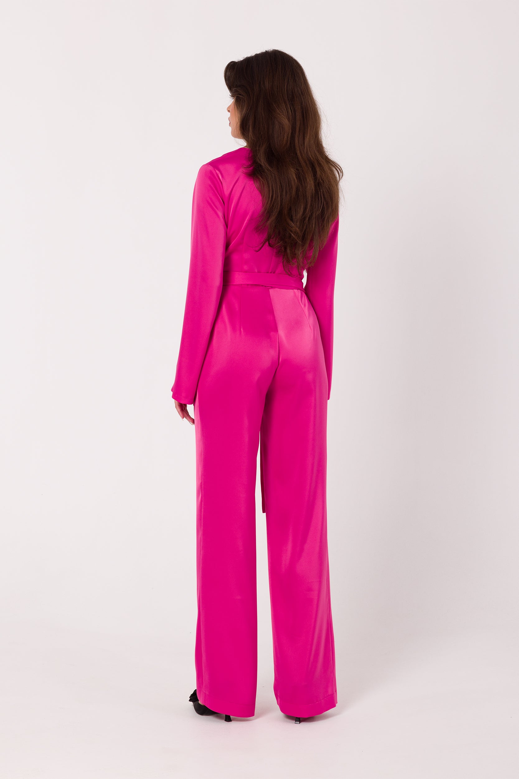 Long Sleeve Pink Satin Jumpsuit | Strictly In | Make a statement at your next event with our Long Sleeve Satin Jumpsuit. Crafted from luxurious satin, it features a V-neck, long sleeves, and a tied waist for a glamorous yet comfortable look. Perfect for the party season.