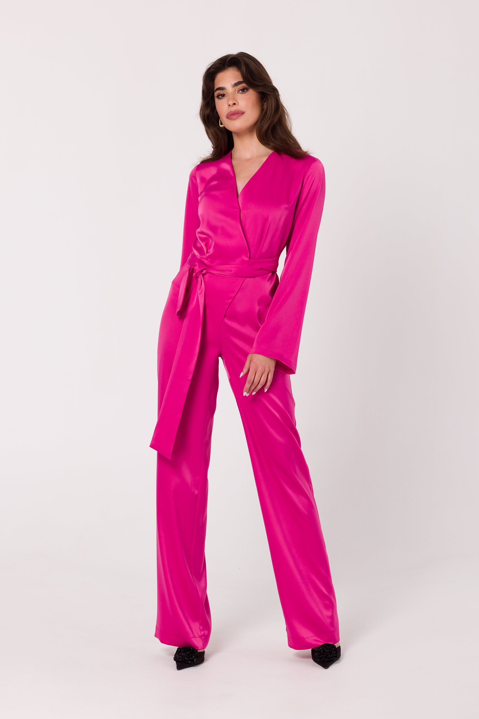 Long Sleeve Pink Satin Jumpsuit | Strictly In | Make a statement at your next event with our Long Sleeve Satin Jumpsuit. Crafted from luxurious satin, it features a V-neck, long sleeves, and a tied waist for a glamorous yet comfortable look. Perfect for the party season.