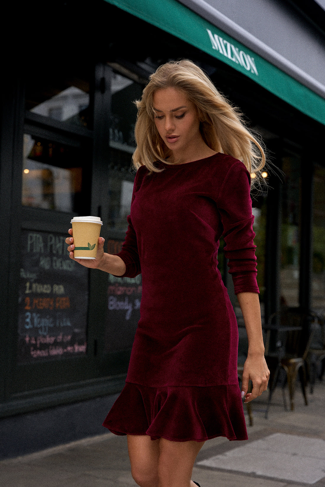 Velvet Charm Dress with Ruffle Hem | Strictly In | Our Velvet Charm dress. Crafted from plush velvet knit, this sheath dress features a flirtatious ruffled hem, ensuring you stand out at any event. Pulled over the head with long sleeves, it's an above-knee stunner for timeless glamour.